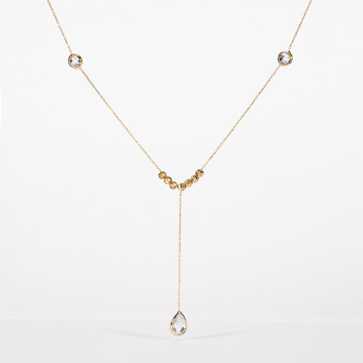 Gold necklace with a teardrop-shaped pendant on a white background