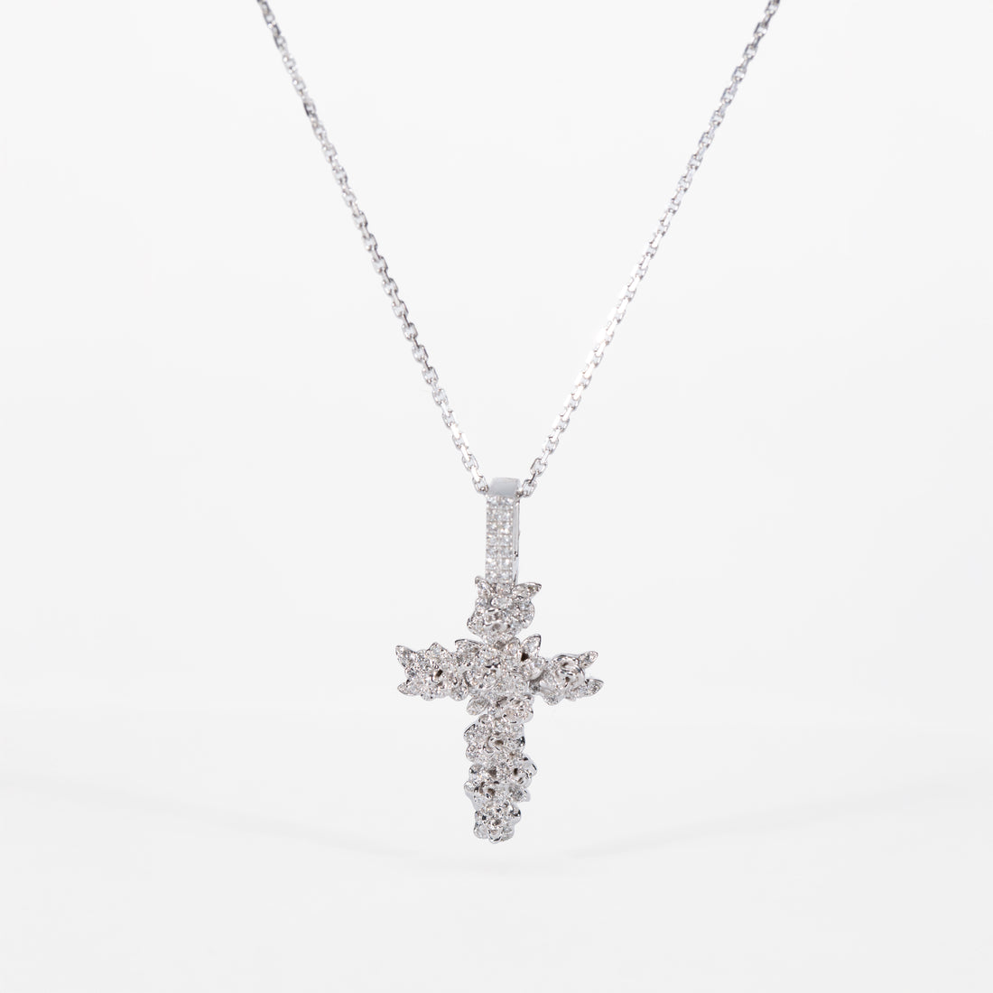 white gold cross pendant necklace on a white background