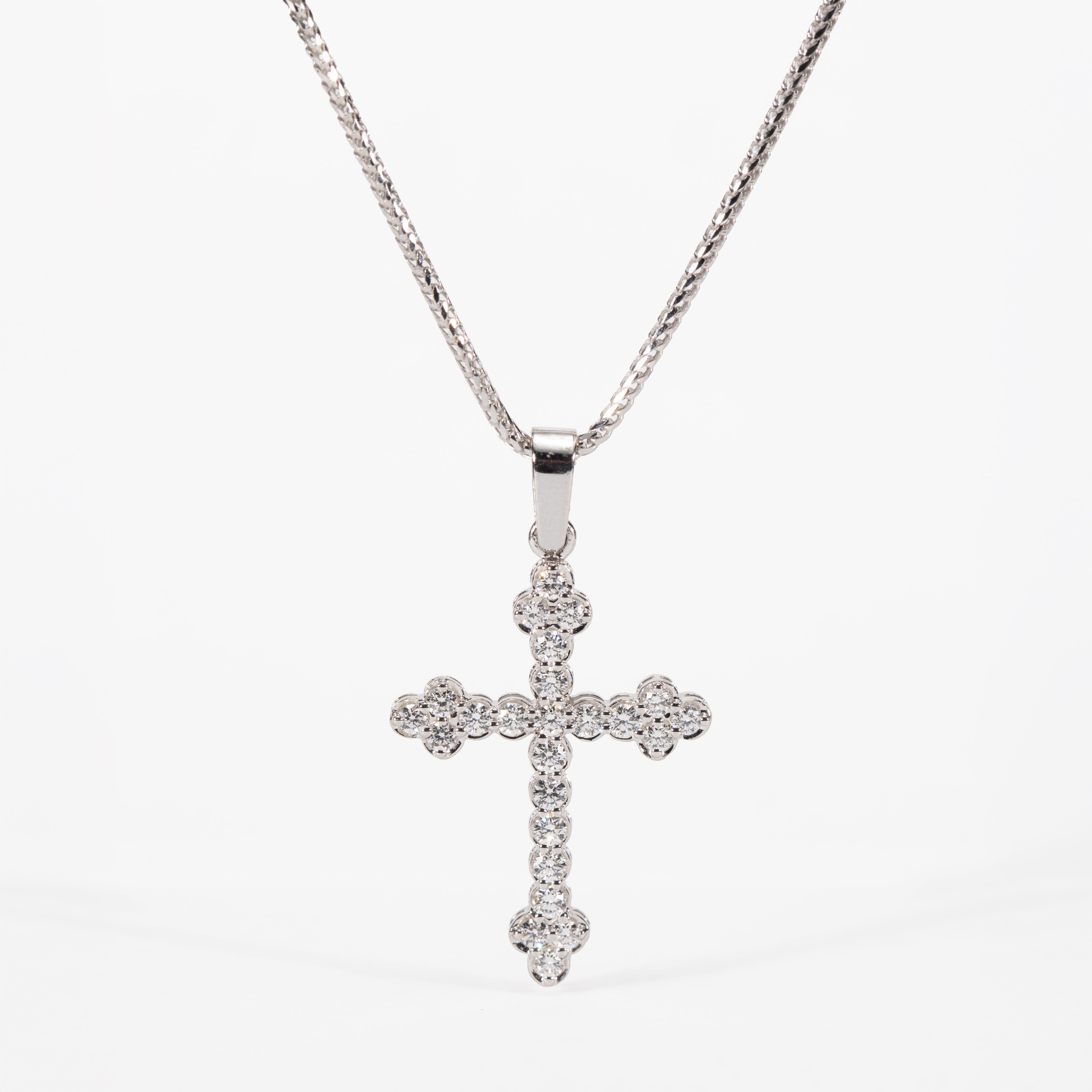 Silver cross pendant necklace on a white background