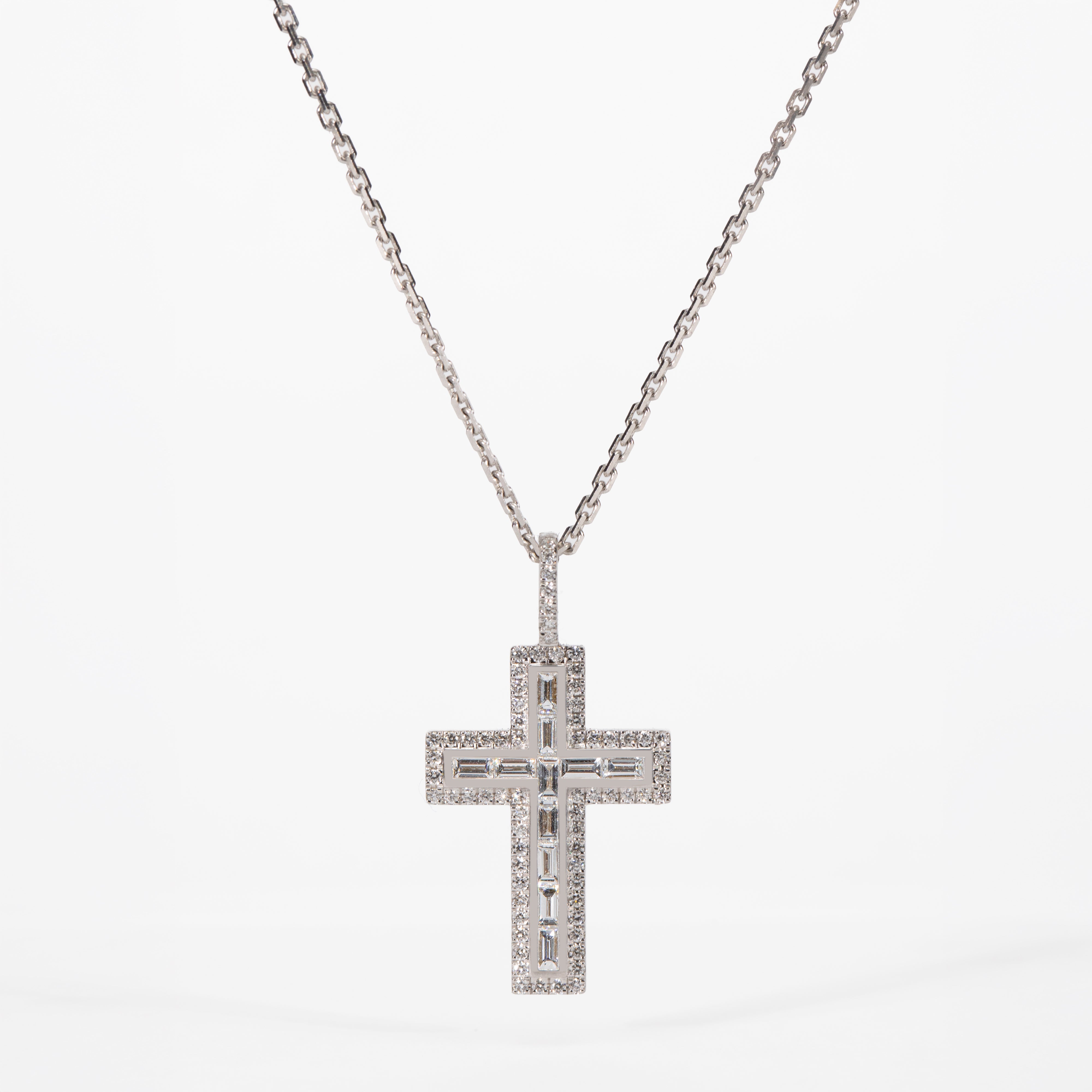 Diamond cross pendant necklace on a white background